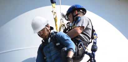 Worker rescuing co-worker at height with controlled ascent device
